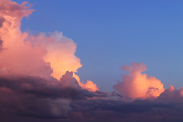 Sunset clouds. Clouds painted pink against a dark sky. Natural background