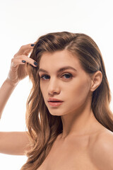 Fototapeta premium A young beautiful woman with long wavy hair striking a confident pose