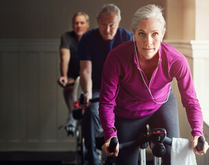 Spin class, gym or senior woman on bike in workout or training for cycling progress, health or...