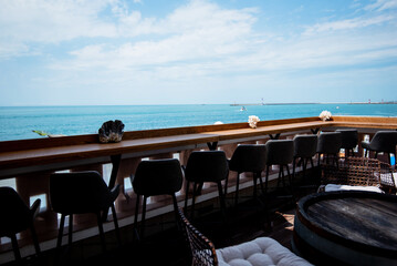 Fototapeta premium Restaurant or cafe on outdoor terrace with view of see. Tourism and travel. Enjoying life. Beautiful places.