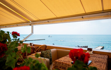 Restaurant or cafe on outdoor terrace with view of see. Tourism and travel. Enjoying life. Beautiful places.