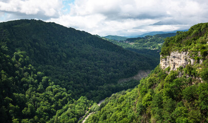 Naklejka premium View of a beautiful mountainous area. Sunny afternoon. Beautiful spring landscape in the mountains. Rocks and dense forest.