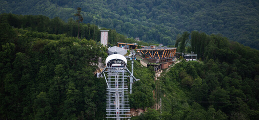View of a suspension bridge in mountains. Travelers crosses hiking on an impressive metal bridge.