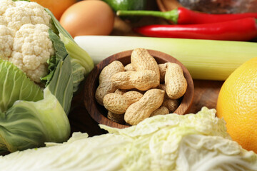 Healthy meal. Different vegetables and peanuts on wooden table, closeup
