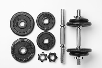Metal dumbbell and parts on white background, top view. Sports equipment