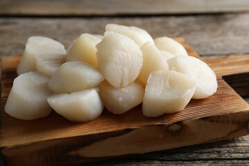 Fresh raw scallops on wooden table, closeup