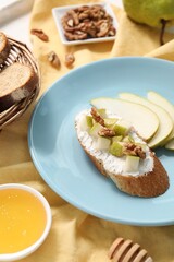 Delicious ricotta bruschetta with pear and walnut served on table, closeup