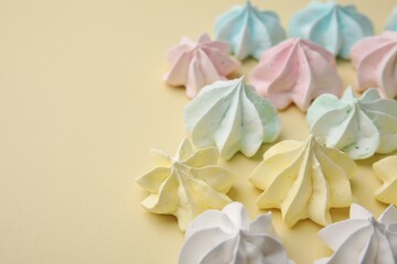 Delicious meringue cookies on beige background, closeup. Space for text