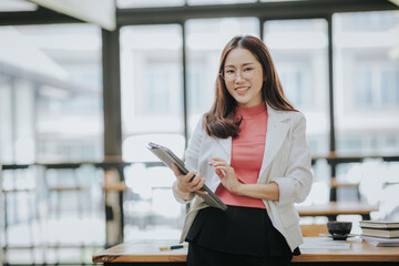 Attractive Asian businesswoman working at modern office with balance sheet documents. Accounting