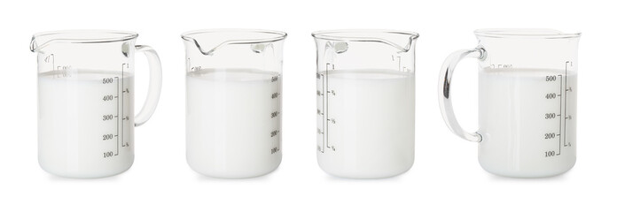 Fresh milk in measuring cup isolated on white, set