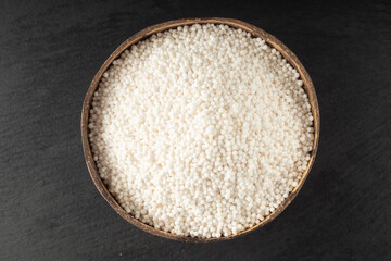 White Sago Pearls in Wooden Bowl Also Know as Sabudana, Tapioca Pearl or Sago Seeds isolated on Gray Background. Top view