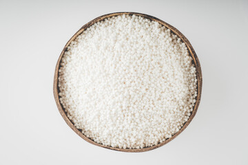 White Sago Pearls in Wooden Bowl Also Know as Sabudana, Tapioca Pearl or Sago Seeds isolated on White Background. Top view