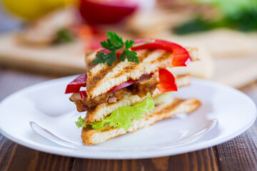 fried toast with chicken, salad, greens on a wooden table