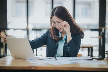 Asian businesswoman who is suffering from headache and stress due to overwork