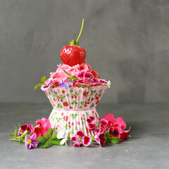 sommerlicher Cupcake mit Buttercreme, Erdbeeren und Blumendekoration
