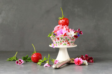 sommerlicher Cupcake mit Buttercreme, Erdbeeren und Blumendekoration