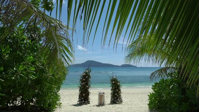 edding decor, white wedding arch decorated with roses on the beach