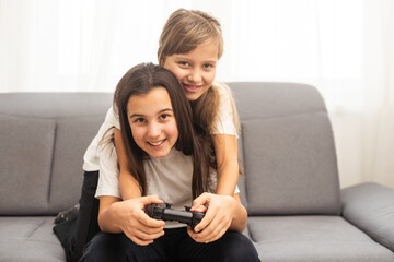 Two middle school girls at home playing an exciting video game together.