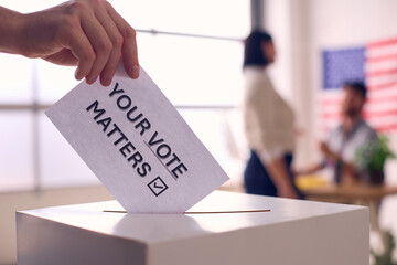 Hand Placing Ballot in Box With Your Vote Matters