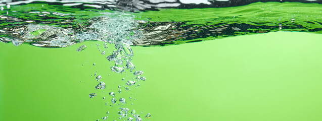 Different waves of air bubbles caused by falling water on a colorful background.
