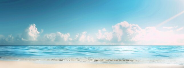 Obraz premium View of a beautiful sandy beach, water, and a sunny blue sky with a few clouds on a hot day.
