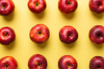 Many red apples on colored background, top view. Autumn pattern with fresh apple above view