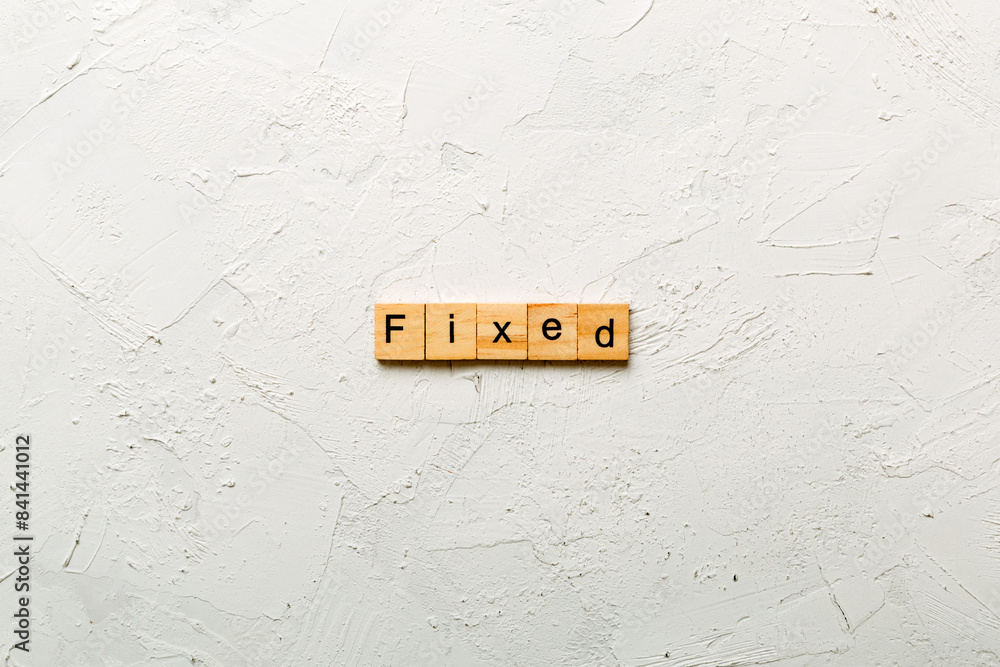 Fototapete fixed word written on wood block. fixed text on table, concept
