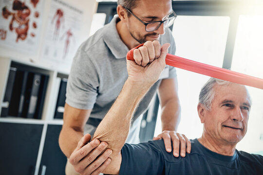 Clinic, physiotherapy and old man with resistance band, stretching and support for senior healthcare. Physio, therapist and elderly patient for mobility training, exercise and help in retirement.