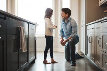 Father, girl and smile in kitchen for talking, love and support for relationship in home. Man,...