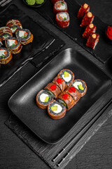 Sushi set composition on black background. The Art of Japanese Cuisine. Food photography for menu and sushi bar decoration