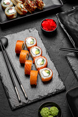 Sushi set composition on black background. The Art of Japanese Cuisine. Food photography for menu and sushi bar decoration