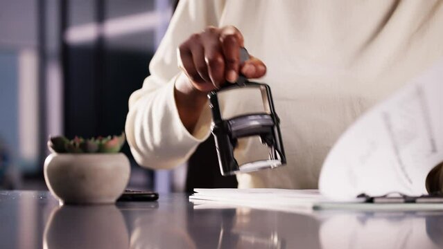 Businesswoman Notarizing Documents With Stamp In Office: Legal Assistant Approving Contracts For African American Company