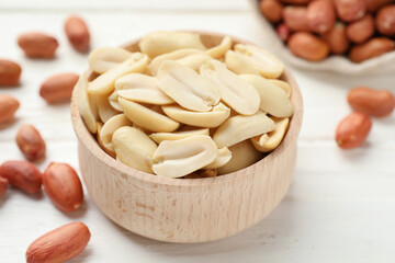 Fresh peanuts in bowl on white table, closeup