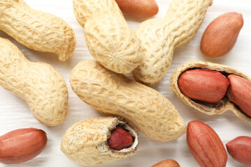Fresh unpeeled peanuts on white wooden table, flat lay
