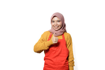 Portrait of smiling woman in hijab and apron showing okay sign with hand isolated on white background.