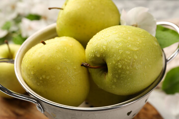 Colander with fresh wet apples on table, closeup