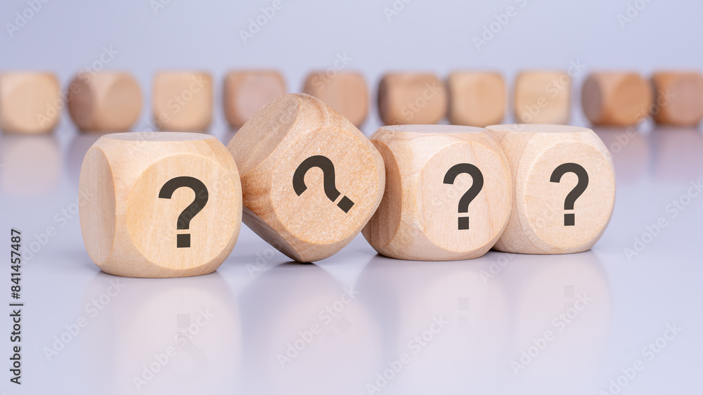 Poster four wooden blocks with question marks over a brown background with copy space