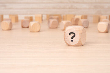 wooden cubes with a question mark engraved on them, front view