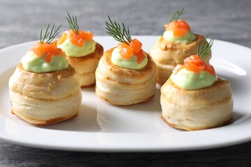 Delicious puff pastry with avocado cream, salmon and dill on table