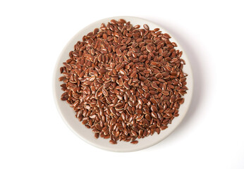 Top view of Brown flax seeds on white plate isolated on white background. Brown Flax Seed is rich in nutrients such as dietary fiber and essential fatty acids that are beneficial to the body.