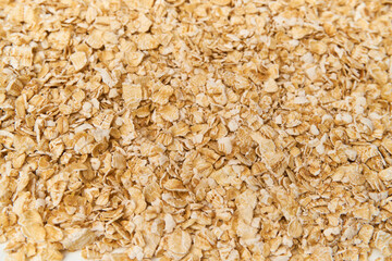 Flat lay of instant oatmeal scattered on white background. Oatmeal is oats that have been ground or processed, cooked quickly within a few minutes, add hot water or warm milk and eat for breakfast.