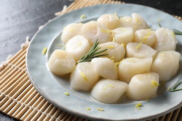 Raw scallops with lemon and rosemary on dark table, closeup