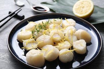 Raw scallops with thyme and lemon zest on grey table, closeup