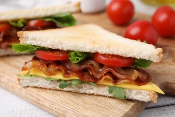 Delicious sandwich with fried bacon on wooden rustic table, closeup