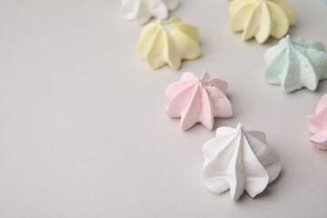 Delicious meringue cookies on light background, closeup. Space for text