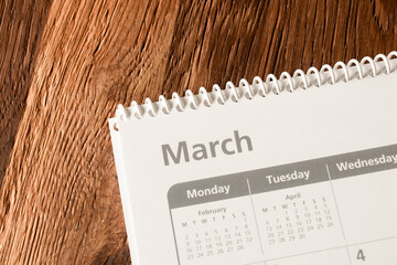 White calendar of the month of March on a wooden background. Planning, goal setting, agenda, planner, organization and time management concept.