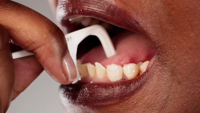 Dental Hygienist Using Floss to Clean Patient's Teeth in Close-up Photo, Perfecting Oral Care