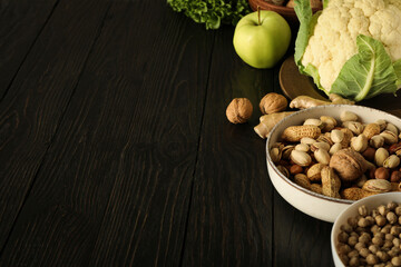 Set of protein products in bowls on wooden background, space for text