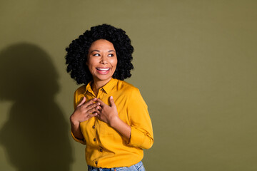 Portrait of pretty lady arms touch chest empty space wear yellow shirt isolated on khaki color background