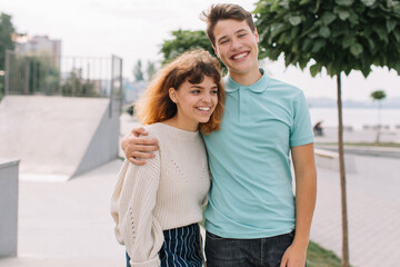 Naklejka premium Two teenagers, boy and girl talking and joking each other at school